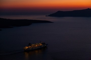 Naklejka premium Nachtaufnahme Caldera von Santorin in Griechenland mit Kreuzfahrschiff von Fira aus