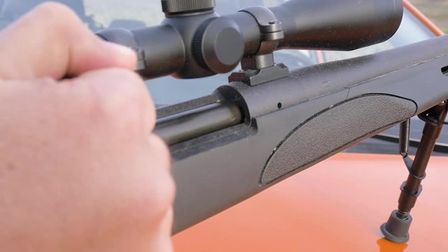 Man loading a semi automatic sniper rifle for target practice. Isolated shot demonstrates second amendment rights and the gun control debate.