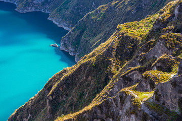 Cliffs with vegetation in the Andes mountains and the magic turquoise waters of the Quilotoa crater lake near Quito, Ecuador. © SL-Photography