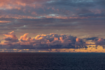 Amazing sunset with colorful clouds and dark ocean water, nature background