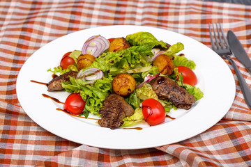 snack with fried chicken liver, potatoes, lettuce, tomatoes and red onion