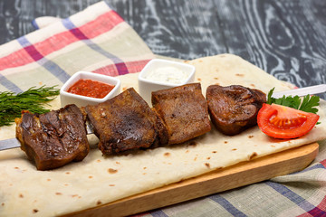 grilled beef kebabs with vegetables and sauces on lavas