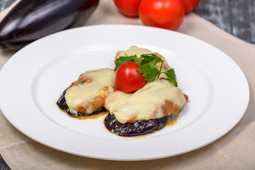 snack of grilled eggplant under cheese with tomatoes and herbs