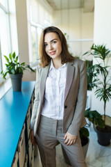 Portrait of a young business woman smiling, in an office environment