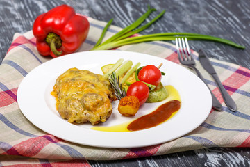 meat baked with cheese, potatoes, sauces and fresh vegetables