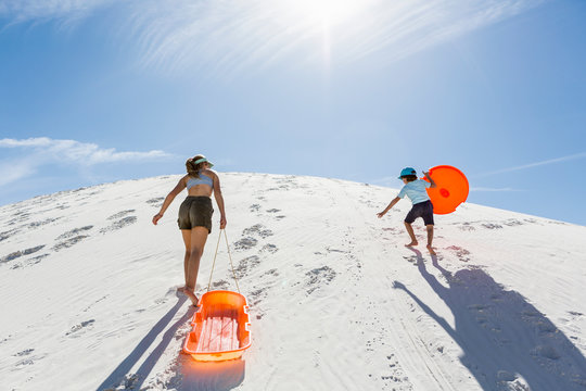 siblings climbing sand dune,White Sands National Monument