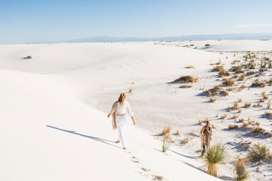 13 year old girl walking across sand dunes leaving footprints,White Sands National Monument