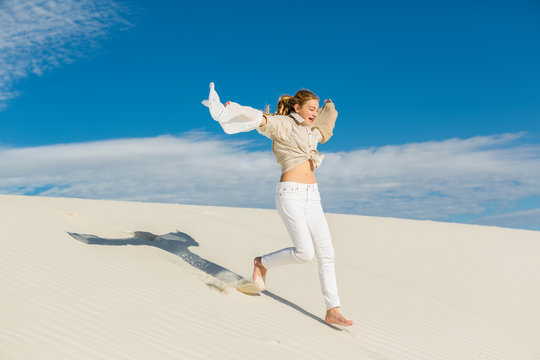 13 Year Old Girl Leaping And Dancing In Light White Sand Sand In A Dunes Landscape. ,White Sands National Monument