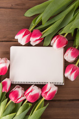 Pink tulips on wooden background. Flat lay, top view. Copy space.