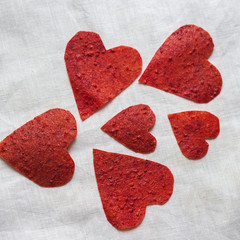Heart piece of strawberry fruit leather on the white background. Flat lay composition. Love concept