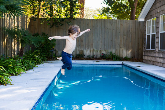 A six year old boy leaping into a swimming pool,St Simon's Island