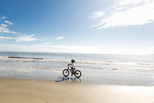 6 year old boy biking on beach, St. Simon's Island, Georgia,St Simon's Island