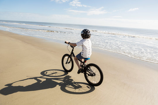 6 year old boy biking on beach, St. Simon's Island, Georgia,St Simon's Island