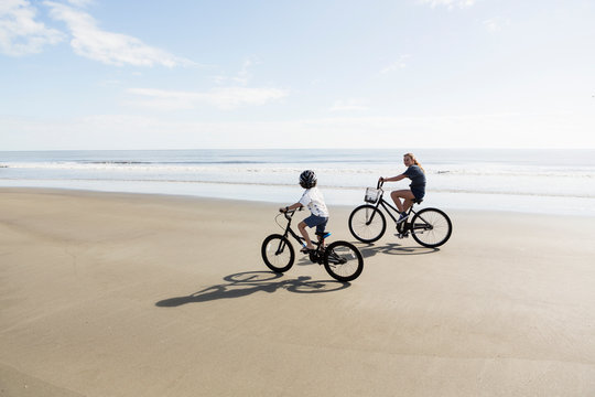 Siblings, a boy and girl cycling on a beach.,St Simon's Island