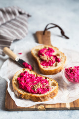 Bruschetta with Beetroot hummus decorated with chopped nuts and microgreen. Vegan recipes, plant-based dishes. Green living concept. Organic food. Vegetarian cuisine. Bread with pink dip
