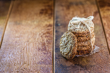 wholemeal biscuit made in a wing, stacked on a rustic wooden background.