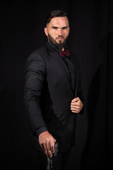 Stylish bearded man with cane in studio