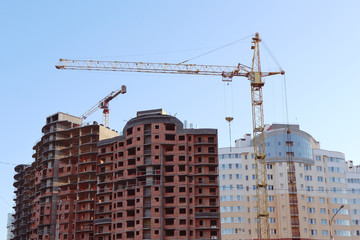 Fototapeta na wymiar Construction of a building with a high crane