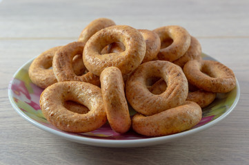 A pile of bagels bread, sushki or baranki in a plate on a wooden table.