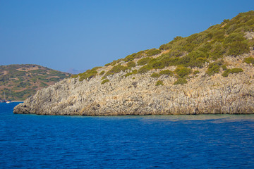 Naklejka premium Sharp stones and rocks in the clear blue water of Aegean sea near the shores of Bodrum city, Mugla. Beautiful Turkish seascape. Aegean coast in Turkey. Travel concept. Water activity