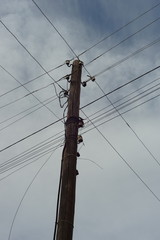 old wooden pillar with wires blue sky background