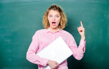 Back to school. School lecturer with notebook. Woman cheerful teacher hold laptop stand near chalkboard. School education concept. Software for teachers. Modern education. Teaching informatics