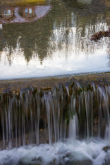 Spiegelung im Wasser mit einem Wasserfall