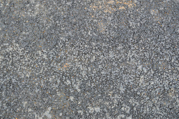 Gray asphalt road with small pebbles and cracks. Texture, background