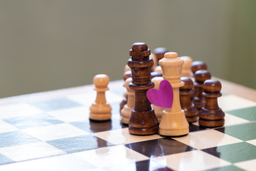 Love and racial prejudice. Chess pieces on a chessboard.