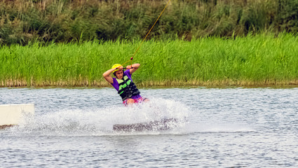 Fototapeta na wymiar Teenager wakeboarding on a lake - Brwinow, Masovia, Poland