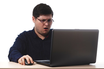 Young guy in a dark blue shirt behind a laptop in glasses for office, business vision on a white background. isolate. copy space