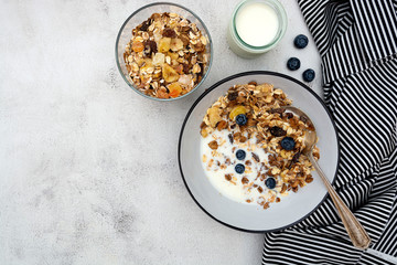 Bowl of oatmeal cereal. Whole oats, granola with dried fruit and blueberry, milk and honey. Healthy food breakfast. Copy space.