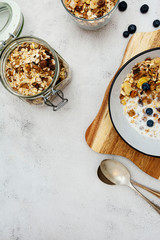 Whole oats breakfast, granola with dried fruit and blueberry, milk and honey. Healthy food, clean eating. Copy space.
