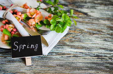 Festive table place setting with spring blossoming branch on wooden background.