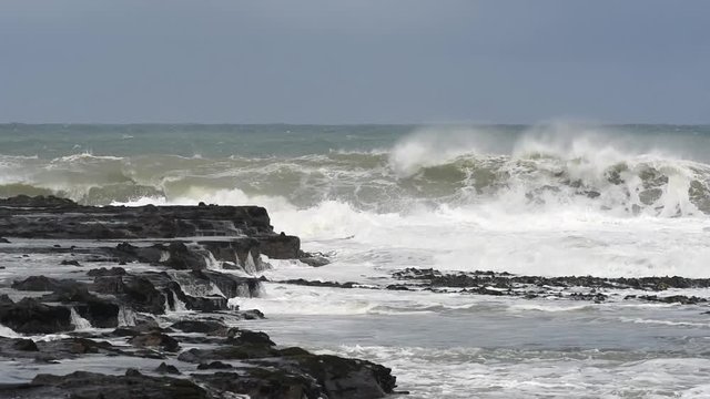 Large waves crashing into the rocky point between Porpoise Bay and Curio Bay on the Catins coast, Otago, New Zealand.