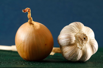 There is an onion and garlic next to each other