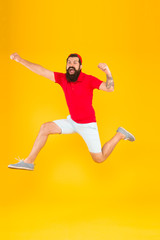 Fototapeta na wymiar Healthy guy feeling good. Inspired concept. Towards fun. Enjoying active lifestyle. Happy guy jumping. Active bearded man in motion yellow background. Active and energetic hipster. Energy charge