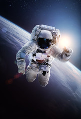 Astronaut in the outer space on orbit of the planet Earth. Abstract wallpaper. Spaceman. Elements...