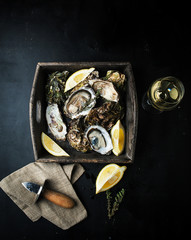 Fresh oysters in a wooden box with lemon