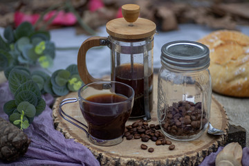 Coffee cup with brewing accessories on wooden board