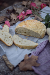 Artisan bread bun sliced on tablecloth in garden