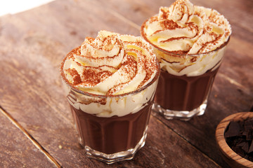Hot chocolate cocoa in glas cup with whipped cream on vintage background