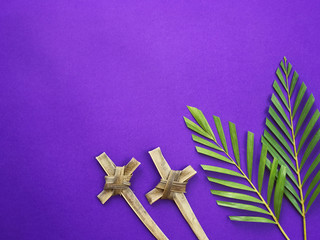 Good Friday, Lent Season, Ash Wednesday, Palm Sunday and Holy Week concept. Crosses made of palm leaves and palm leaves on purple background.