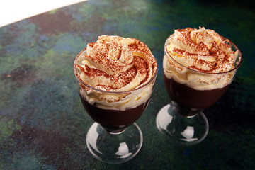 Hot chocolate cocoa in glas cup with whipped cream on vintage background