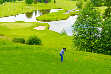 Golf course with gorgeous green and pond. © karamysh