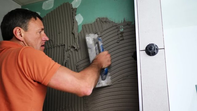 Fliesenleger Verlegen fliesen in einem modernem badezimmer 4k video in zeitlupe