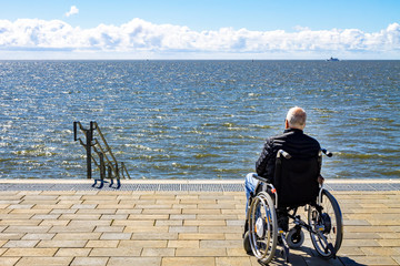 Obraz premium Rollstuhlfahrer am Meer 