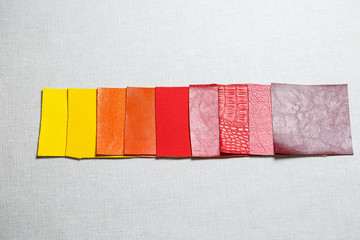 Fototapeta na wymiar square pieces of multi-colored fabric laid out on a gray background