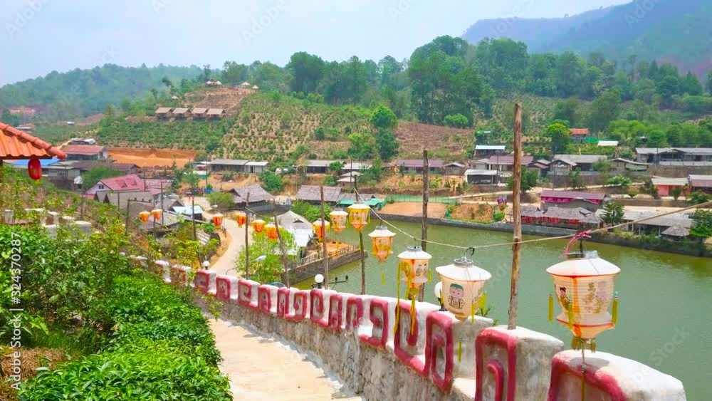 Poster BAN RAK THAI, THAILAND - MAY 6, 2019: Walk the fortress wall with hanging Chinese lanterns and observe Yunnan tea village around Mae Sa-Nga lake, on May 6 in Ban Rak Thai