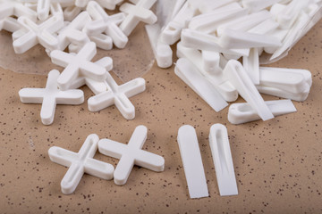 White plastic clinics and crosses for laying ceramic tiles. Accessories and tools necessary for construction workers.
